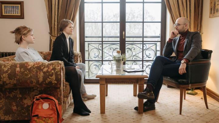 Therapeut in gesprek met cliënten in een spreekkamer